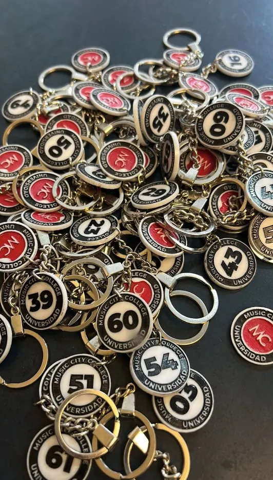 Montón de llaveros numerados con logotipo, producidos en serie