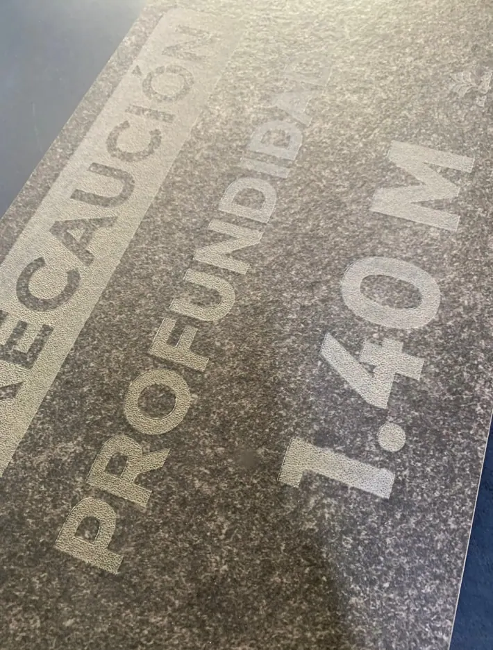 Placa de granito con una advertencia de profundidad grabada
