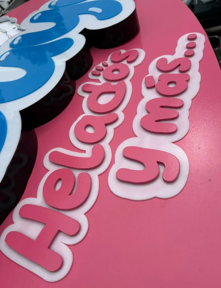 Letras de acrílico rosa y azul en relieve para un anuncio