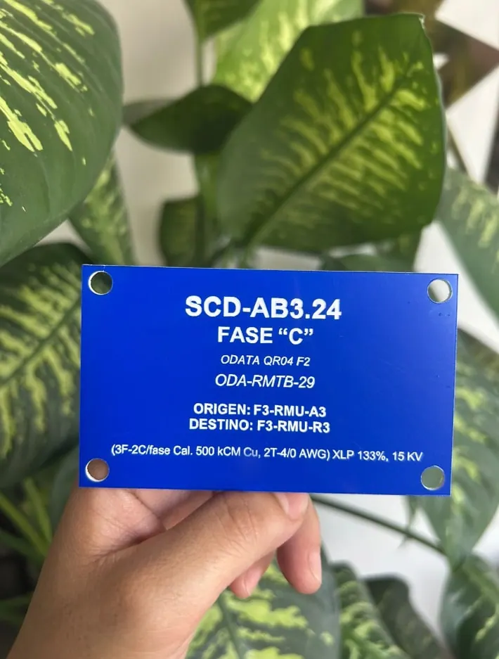 Placa azul de identificación eléctrica con datos de fase grabados en blanco