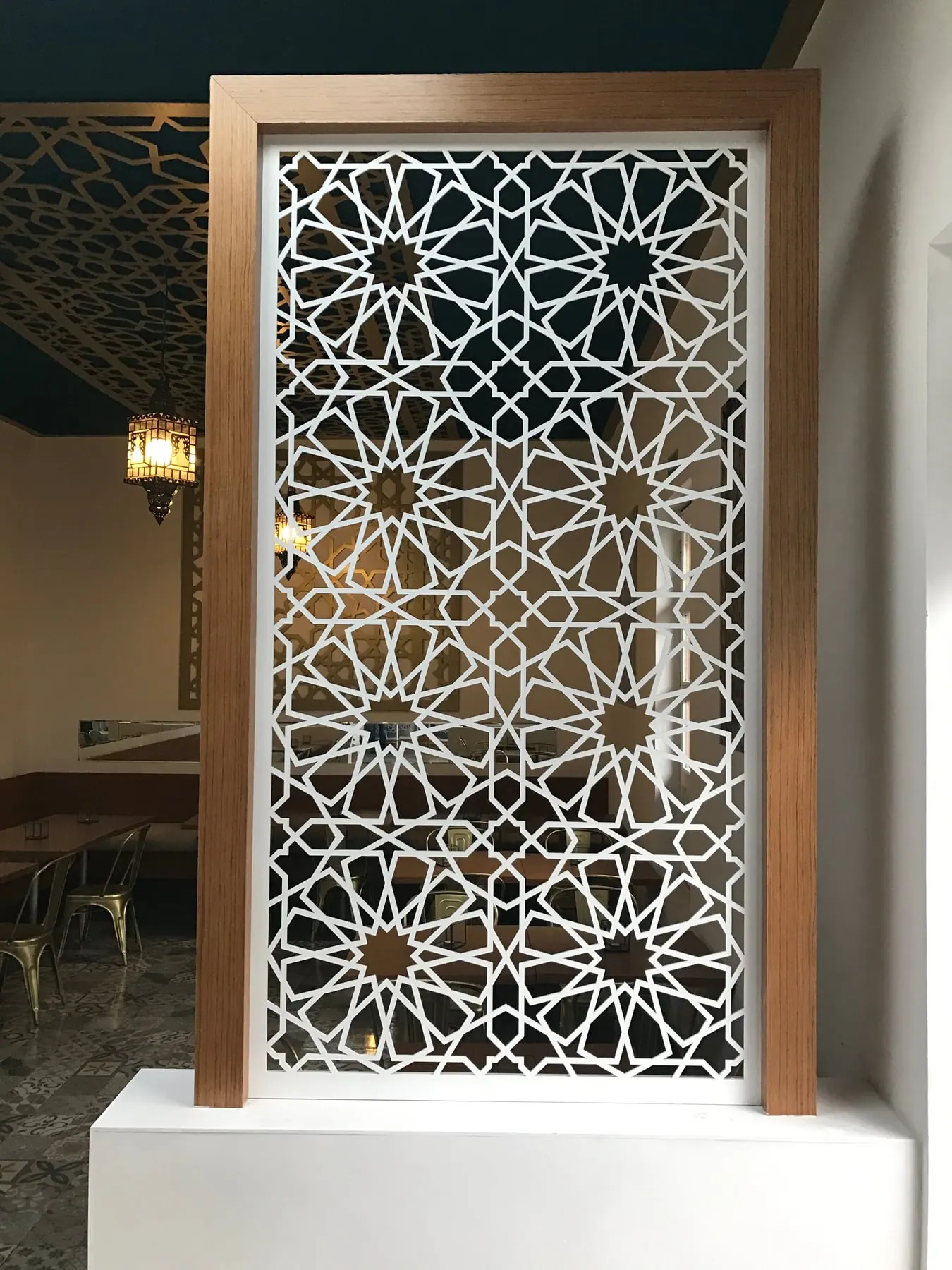 Celosía blanca de patrón árabe en un marco de madera