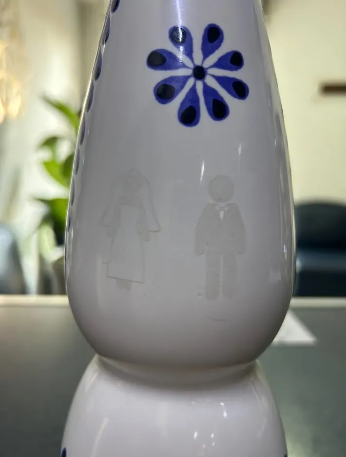Botella de cerámica con figuras de novios grabadas