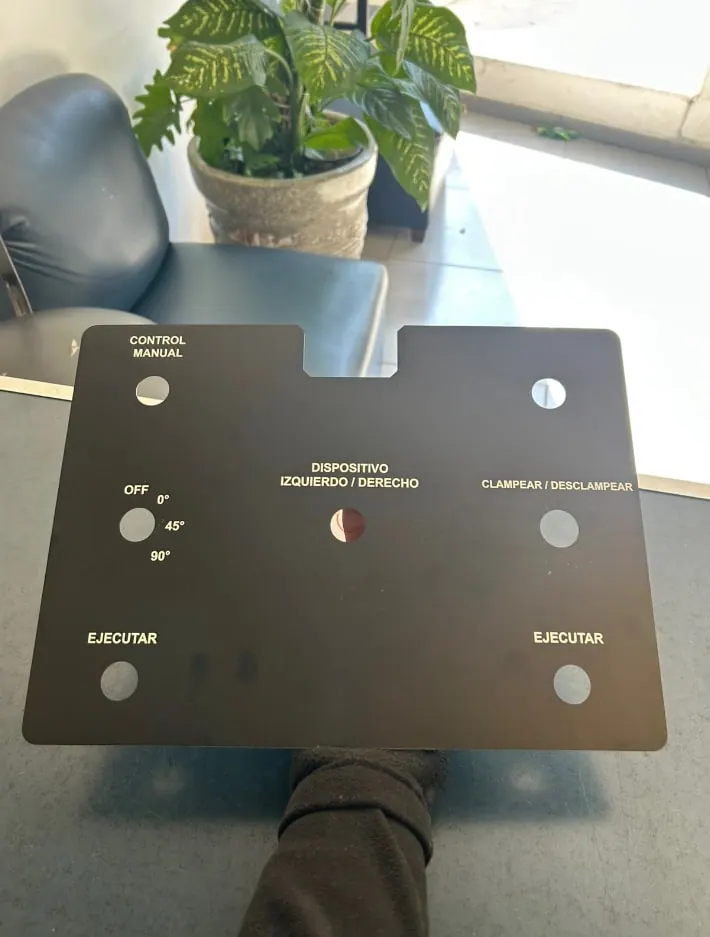 Panel de control de aluminio anodizado negro con perforaciones y rótulos grabados en blanco