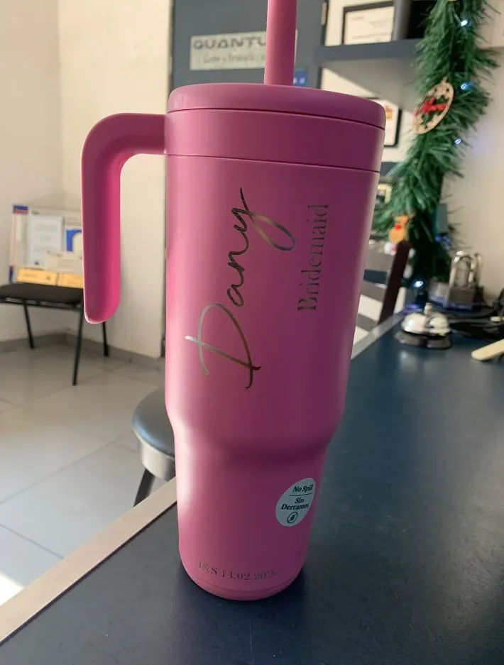Vaso rosa con asa y un nombre grabado