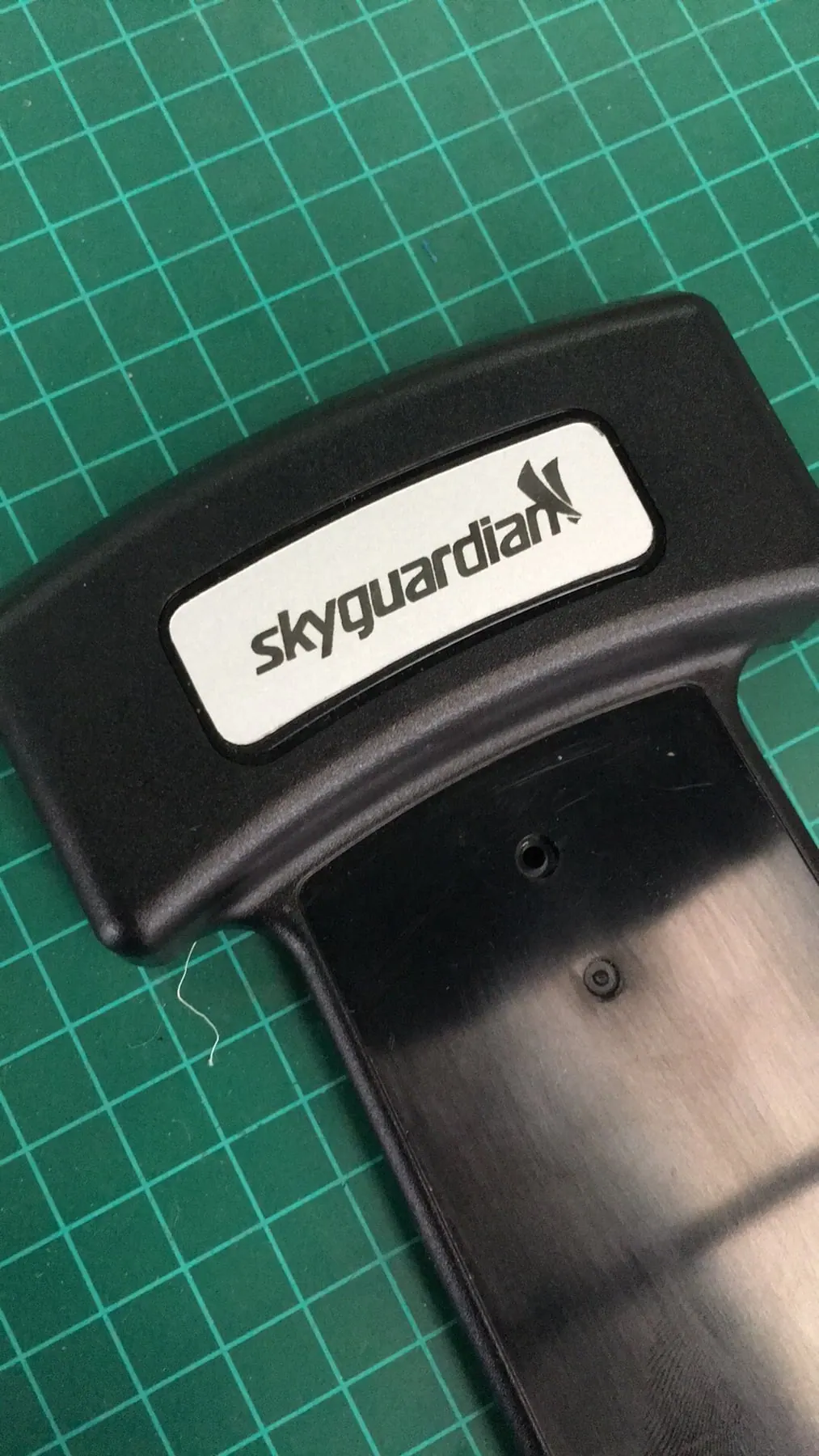 Logotipo marcado en blanco sobre una pieza de plástico negro